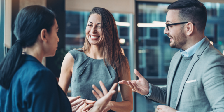 A group of business men and women talking and networking with each other.